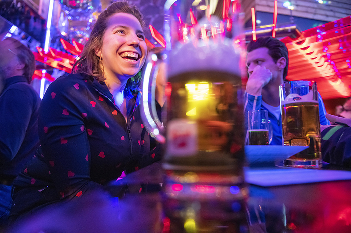 Natte horeca Attractive young woman laughing in a bar with friends, celebrating. Alcoholic drinks, responsible
