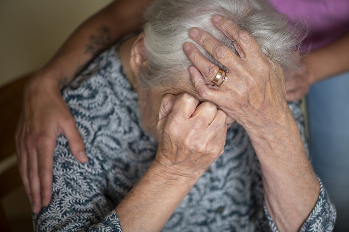 Verdriet bij ouderen Upset elderly lady being comforted by her helped. Devastated, crying,