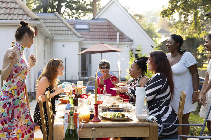 A mixed gathering of women laughing and having fun at a summer garden birthday party celebration lunch A mixed gathering of women laughing and having fun at a summer garden birthday party celebration lunch