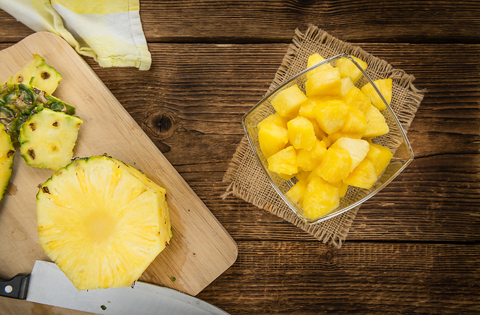 Wooden table with Sliced Pineapple, selective focus Wooden table with Sliced Pineapple, selective focus, by Zoonar Christoph Sch