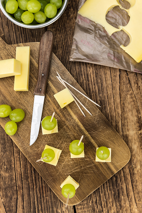 Old wooden table with Cheese blocks and grapes  partyfood  Old wooden table with Cheese blocks and grapes  partyfood , by Zoonar Christoph Sch