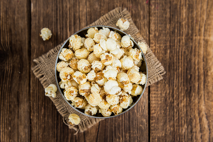 Portion of Popcorn on wooden background, selective focus Portion of Popcorn on wooden background, selective focus, by Zoonar Christoph Sch