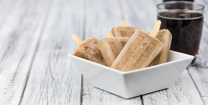 Fresh made Cola Popsicles on wooden background Fresh made Cola Popsicles on wooden background, by Zoonar Christoph Sch