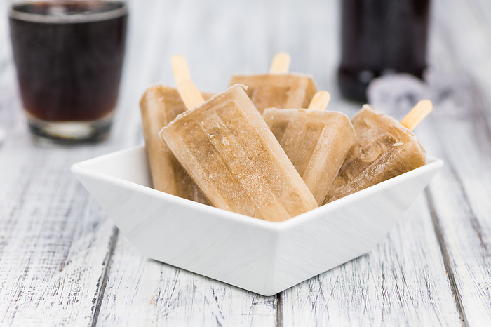 Fresh made Cola Popsicles on wooden background Fresh made Cola Popsicles on wooden background, by Zoonar Christoph Sch