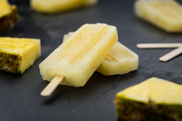 Portion of Pineapple Popsicles on a slate slab  selective focus  close up shot  Portion of Pineapple Popsicles on a slate slab  selective focus  close up shot , by Zoonar Christoph Sch