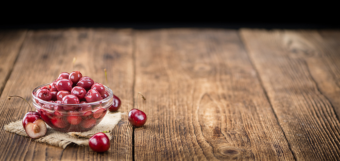 Portion of Canned Cherries on wooden background, selective focus Portion of Canned Cherries on wooden background, selective focus, by Zoonar Christoph Sch