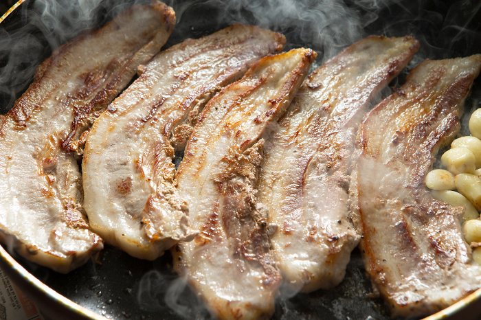 sliced pork belly cooked on a tabletop grill