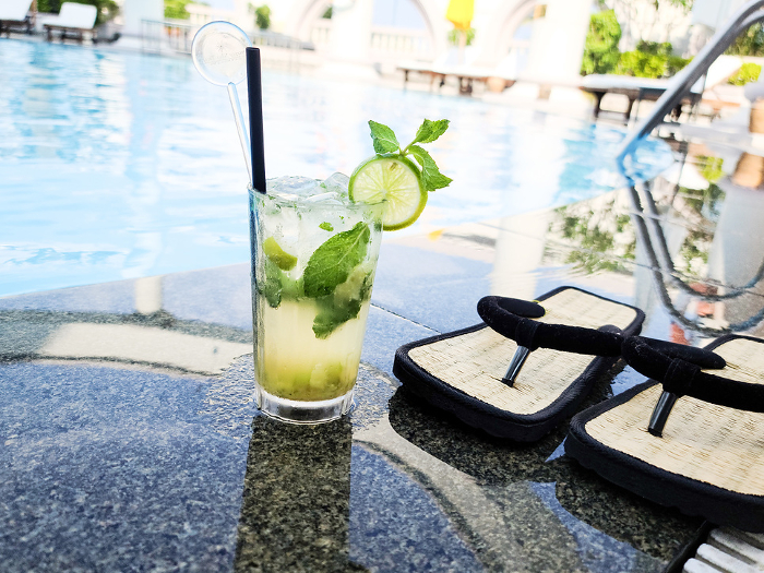 Cocktails and sandals placed by the pool