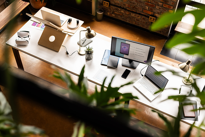 A modern office setup showcases a clean, casual business workspace. The desk is equipped with tech gadgets, reflecting a professional environment.