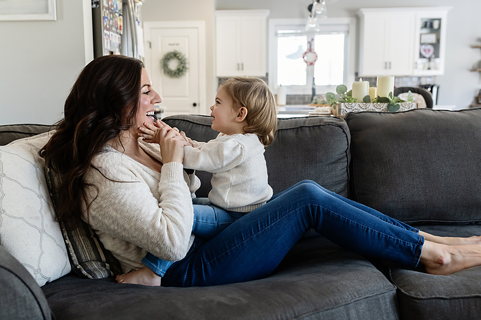 Mother and Baby having a fun moment together on Couch, by Cavan Images / Katie Pugliese Photography LLC