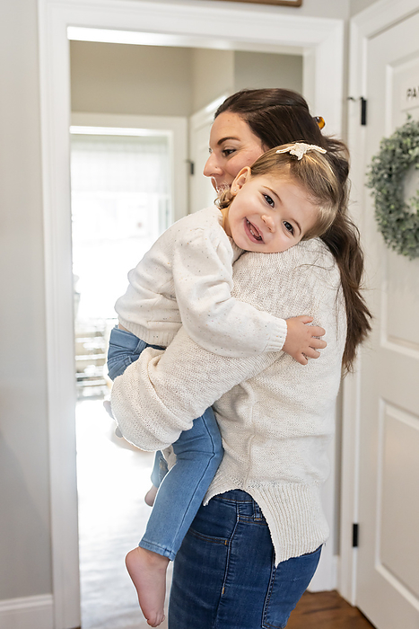 Vertical Image of mom holding toddler girl in a sweet embrace, by Cavan Images / Katie Pugliese Photography LLC