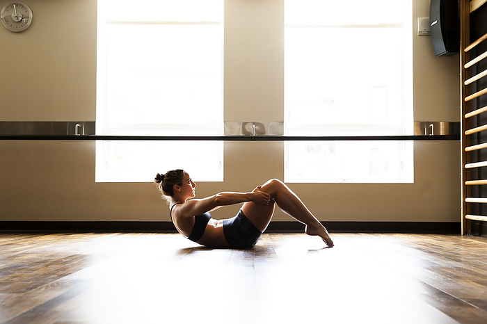 Woman in C-Curve in Fitness Studio, by Cavan Images / Lucie Wicker