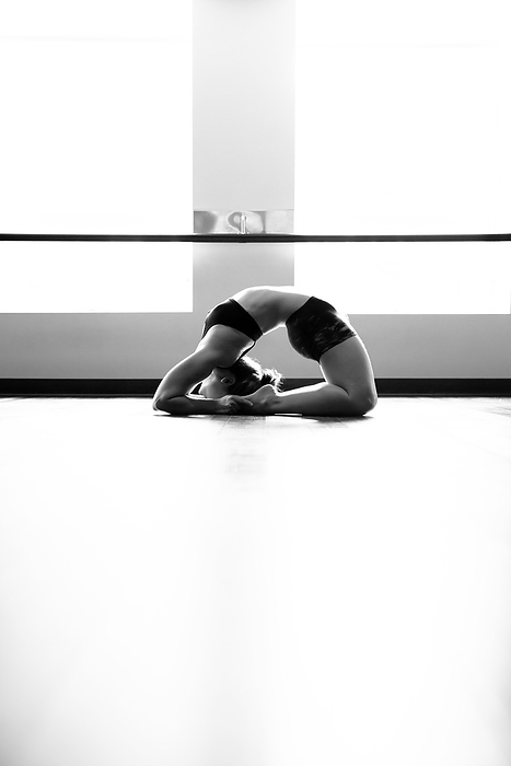 Woman in Back Bend Yoga Pose in Studio, by Cavan Images / Lucie Wicker