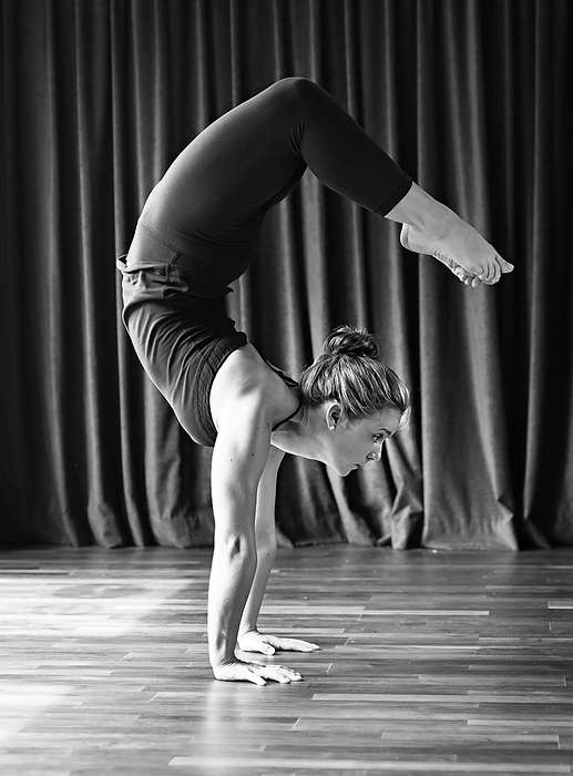 Woman in Scorpion Pose in Yoga Studio, by Cavan Images / Lucie Wicker