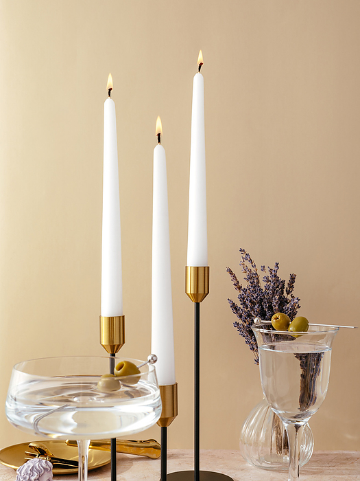 candles stand on the table in tall metal candlesticks. festive t, by Cavan Images / Aleksandr Kuzmin
