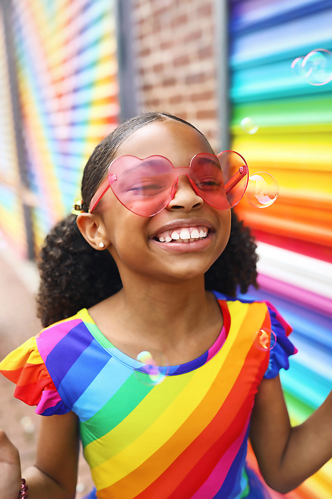 Young Girl with Big Smile in front of a mural in Washington, DC, by Cavan Images / Nikia Paden
