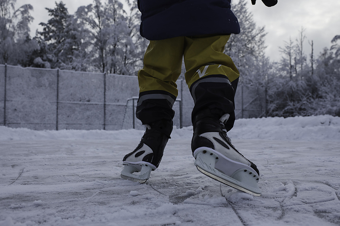 child ice skating outside in the snow in Sweden, by Cavan Images / Rachel Bell