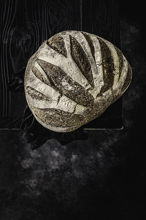 Loaf of Country Bread on Wooden Table, by Cavan Images / Sara Ghedina