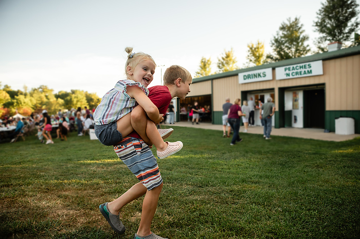 Happy children at outdoor summer festival, by Cavan Images / Krista Taylor