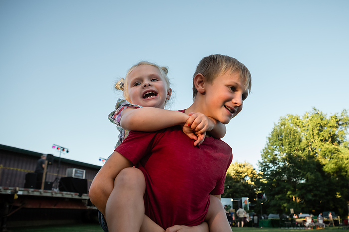 Happy children at outdoor summer concert, by Cavan Images / Krista Taylor