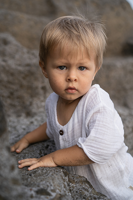 Portrait of a small blond child boy on the beach., by Cavan Images / Yuliya Kirayonak