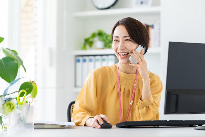 Middle Japanese businesswoman on the phone in office (Female / People)