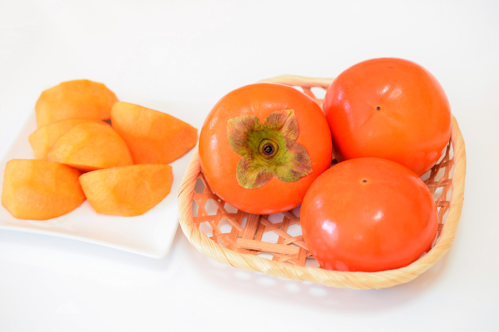 Fuyu persimmon on the table, persimmon in a basket