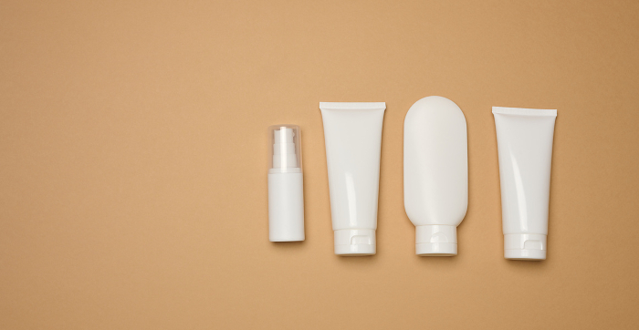 White plastic tubes, jars, and containers for cosmetic products on a brown background, advertising and branding of products White plastic tubes, jars, and containers for cosmetic products on a brown background, advertising and branding of products