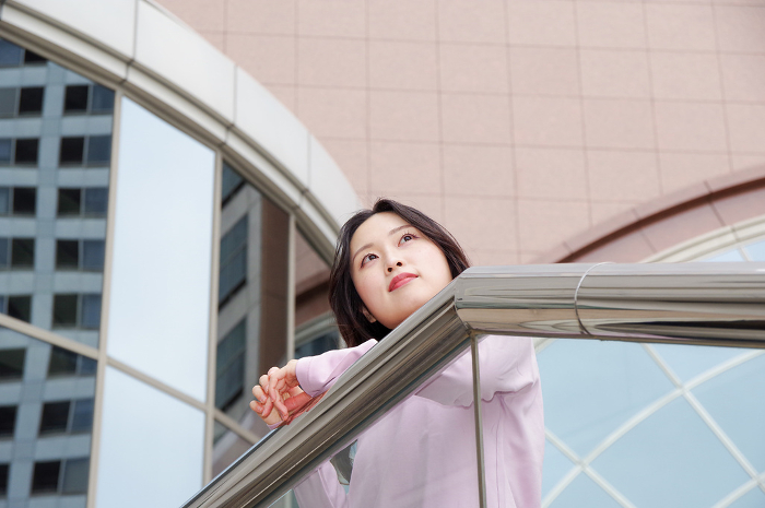 Woman looking into the distance from an outdoor staircase