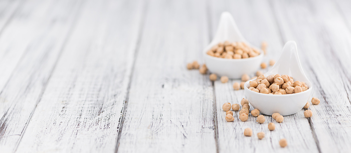 Portion of dried Chickpeas on wooden background, selective focus Portion of dried Chickpeas on wooden background, selective focus, by Zoonar Christoph Sch