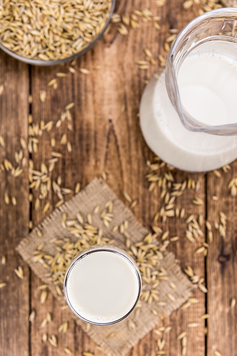 Portion of healthy Oat Milk on an old wooden table  selective focus  close up shot  Portion of healthy Oat Milk on an old wooden table  selective focus  close up shot , by Zoonar Christoph Sch