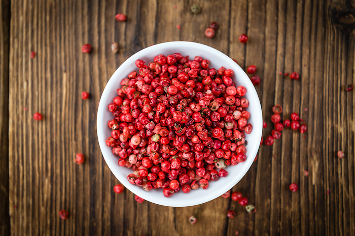 Pink Peppercorns on wooden background  selective focus Pink Peppercorns on wooden background  selective focus, by Zoonar Christoph Sch