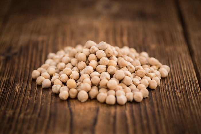 Portion of dried Chickpeas on wooden background, selective focus Portion of dried Chickpeas on wooden background, selective focus, by Zoonar Christoph Sch
