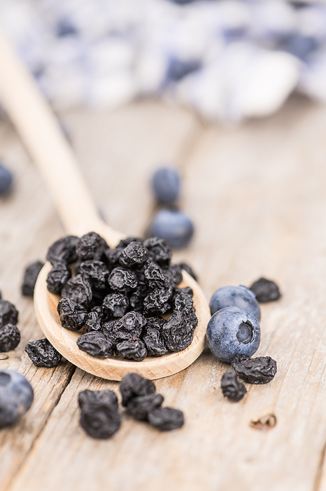 Portion of Dried Blueberries on wooden background, selective focus Portion of Dried Blueberries on wooden background, selective focus, by Zoonar Christoph Sch