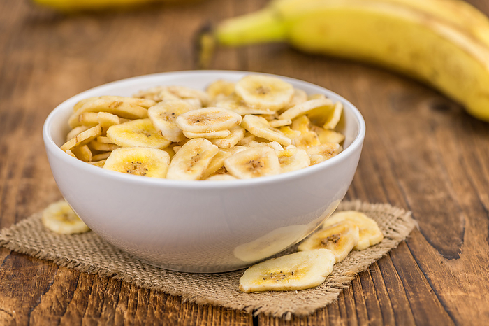 Dried Banana Chips on wooden background  selective focus Dried Banana Chips on wooden background  selective focus, by Zoonar Christoph Sch
