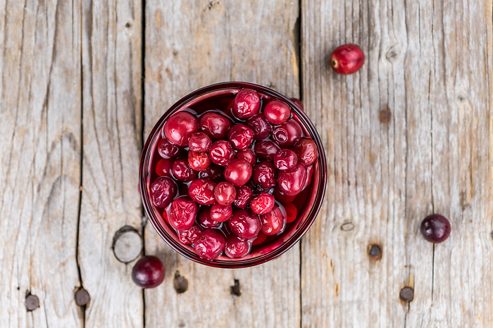 Wooden table with Cranberries  preserved   detailed close up shot  selective focus  Wooden table with Cranberries  preserved   detailed close up shot  selective focus , by Zoonar Christoph Sch