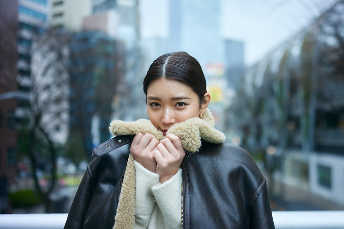 Japanese woman tightening the collar of her coat