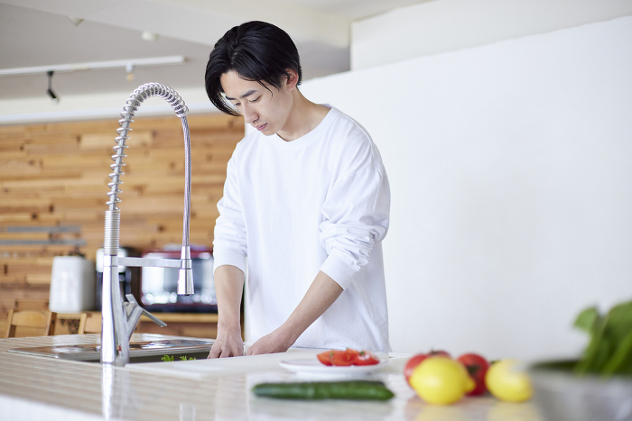 Young Japanese man doing housework in the kitchen (People)