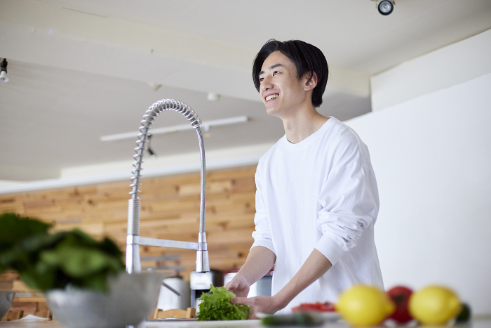 Young Japanese man doing housework in the kitchen (People)