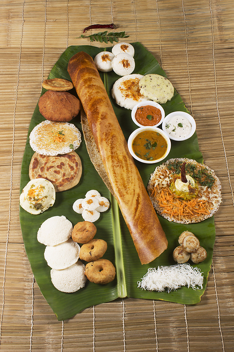 Traditional South Indian snacks, Dosa, idli, medu wada on banana leaf. Traditional South Indian snacks, Dosa, idli, medu wada on banana leaf., by Zoonar RealityImages