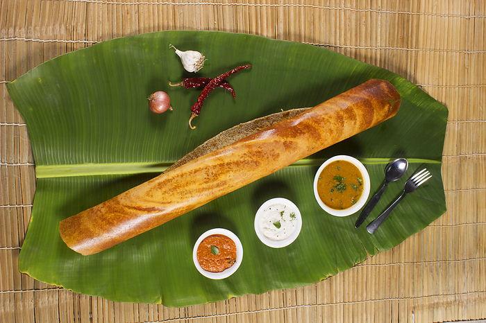 Masala dosa on banana leaf with both sambar and coconut chutney. South Indian Vegetarian Snack Masala dosa on banana leaf with both sambar and coconut chutney. South Indian Vegetarian Snack, by Zoonar RealityImages