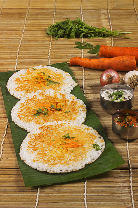 Thick spongy dosas served together with coconut chutney and sambhar on banana leaf Thick spongy dosas served together with coconut chutney and sambhar on banana leaf, by Zoonar RealityImages