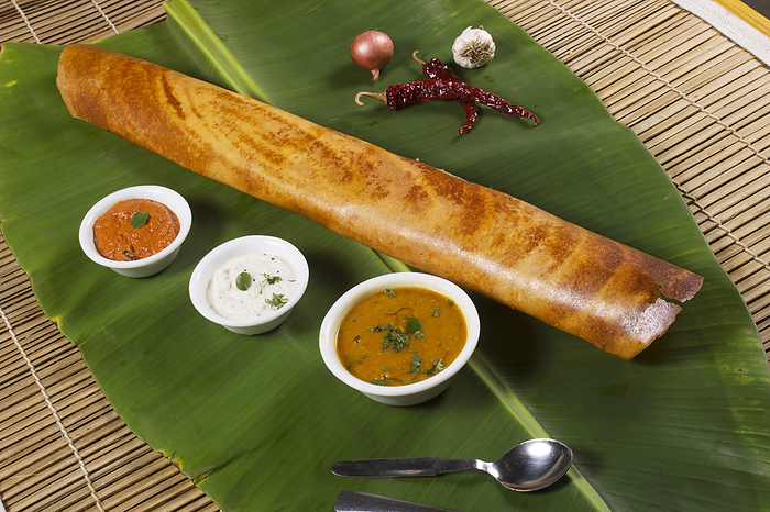 Masala dosa on banana leaf with both sambar and coconut chutney. South Indian Vegetarian Snack Masala dosa on banana leaf with both sambar and coconut chutney. South Indian Vegetarian Snack, by Zoonar RealityImages