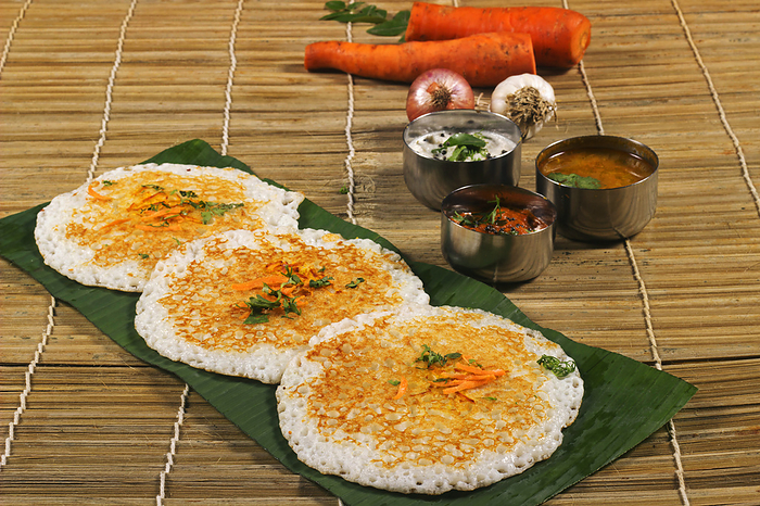 Thick spongy dosas served together with coconut chutney and sambhar on banana leaf Thick spongy dosas served together with coconut chutney and sambhar on banana leaf, by Zoonar RealityImages
