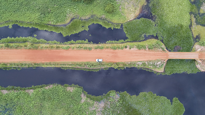 Aerial view vertical down of Transpantaneira dirt road with a car and adjoining blue lagoons and gre Aerial view vertical down of Transpantaneira dirt road with a car and adjoining blue lagoons and gre, by Zoonar Uwe Bergwitz