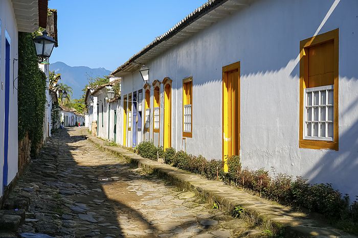 Typical cobblestone street with colorful colonial buildings in the late afternoon sun in historic town Paraty, Brazil Typical cobblestone street with colorful colonial buildings in the late afternoon sun in historic town Paraty, Brazil, by Zoonar Uwe Bergwitz