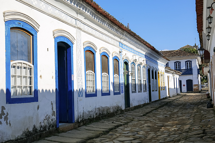 Typical cobblestone street with white colonial buildings and blue framed windows and doors in late a Typical cobblestone street with white colonial buildings and blue framed windows and doors in late a, by Zoonar Uwe Bergwitz