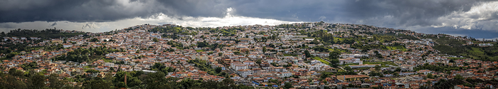 Panoramic aerial view with sunshine and dark cloudy sky of the historic town Diamantina nestled agai Panoramic aerial view with sunshine and dark cloudy sky of the historic town Diamantina nestled agai, by Zoonar Uwe Bergwitz