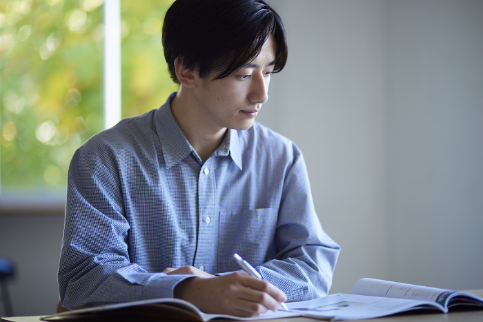 A Japanese university student studying in the living room of his house.