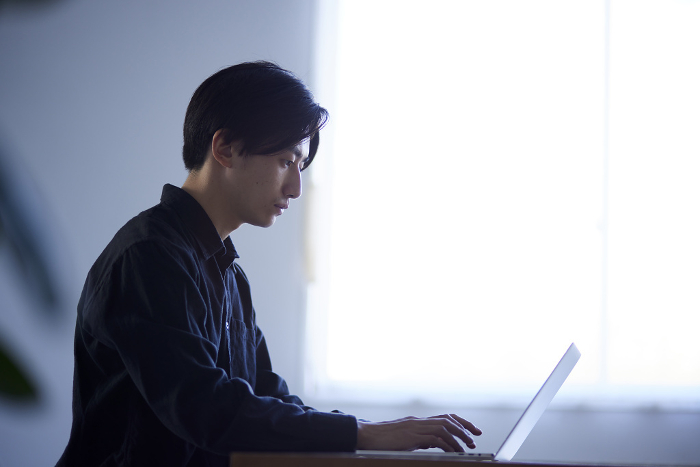 Japanese man using laptop computer (People)